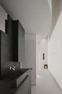 A modern kitchen with a concrete counter, sink, and dim lighting creating a cozy atmosphere