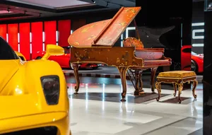 A modern showroom with a piano and a yellow car, well-lit and inviting