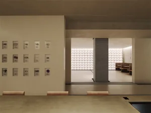 A well-lit room with white walls, artwork, and natural light
