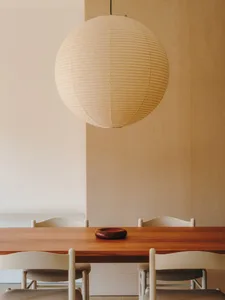 Dining room with a wooden table and chairs, well-lit and inviting, with a bowl on the table