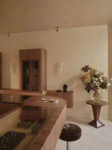 A dimly lit kitchen with a wooden countertop, a wooden cabinet, and a vase, creating a warm and inviting atmosphere