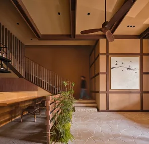 Dining room with wooden floor, staircase, and traditional furniture, well-lit with natural light from a window