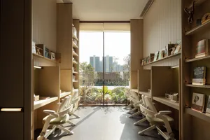 A modern office space with natural light, featuring multiple chairs and a desk, arranged in a comfortable and inviting atmosphere