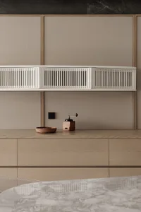 Modern kitchen with wooden cabinets, a white shelf, a bowl, and a coffee maker, with natural light and a bright atmosphere