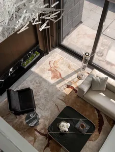Comfortable and inviting living space with a large rug, couch, chair, and coffee table, surrounded by marble and wood accents, and filled with natural light