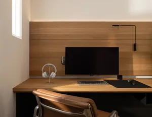 A home office with a wooden desk, chair, and computer monitor, creating a warm and cozy atmosphere