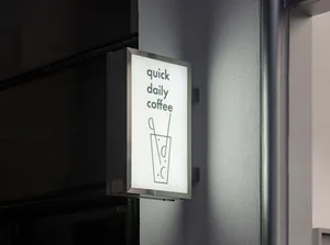 A small, dimly lit coffee shop with a warm atmosphere and an illuminated sign reading Quick Daily Coffee