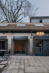 A modern restaurant with a dining table and chairs near a large window and door, with natural light and a bright atmosphere