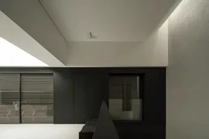 A dark and moody kitchen with a black and white color scheme, featuring a window on the right and a sink on the left