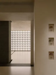 Bright and welcoming hallway with a concrete staircase, white walls, and natural light