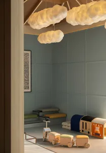 A child's bedroom with a blue wall, featuring a bed, a bench, and a chair, in a well-lit and inviting space