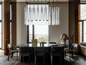 Modern dining space with a glass chandelier, wooden chairs, and a black and white color scheme, set against a window background