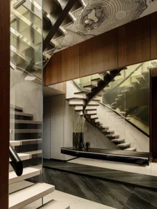 A modern building hallway with a spiral staircase made of wood and glass railing, a bench, and bright lighting
