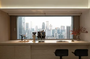 Modern kitchen and dining space with a large window offering a city view, marble countertops and flooring, and a glass window, featuring a chair, potted plant, and dining table