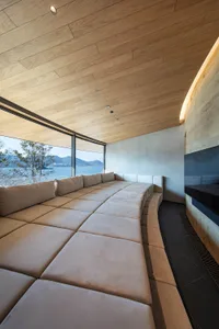 A modern living room with a large couch and chair, natural light, and a bright atmosphere