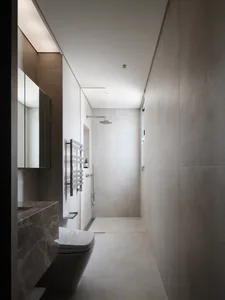 A modern bathroom with a white toilet and sink, a large mirror above the sink, and natural light from a window
