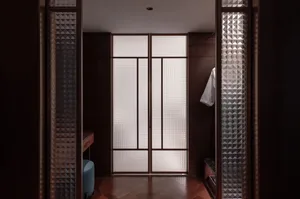 Cozy residential hallway with a wooden floor, glass doors and walls, and dim lighting