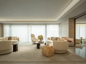 Comfortable living space with a white carpet, modern furniture, and elegant touches from a vase with flowers