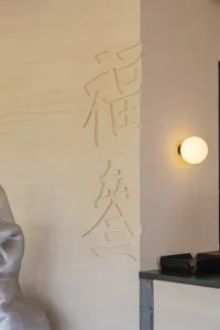 A stone wall with intricate Chinese character carvings, showcasing the artistry and craftsmanship of the piece