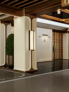 A bright and welcoming hallway with a large white concrete wall and a potted plant, adding a touch of greenery to the space