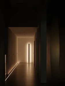 Brightly lit hallway with white walls, a tile floor, and a doorway at the end, creating a warm and inviting atmosphere