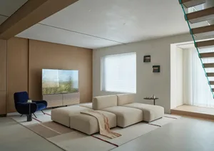 A well-lit living room with a large couch, flat screen TV, rug, chair, and two lamps, creating a comfortable and inviting atmosphere