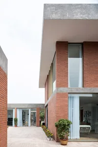一座現代住宅大樓，白色屋頂，巨大的窗戶，設在一座充滿樹木的住宅區域內
