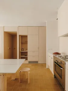 Warm and inviting kitchen and dining area with wooden elements, natural light, and a potted plant