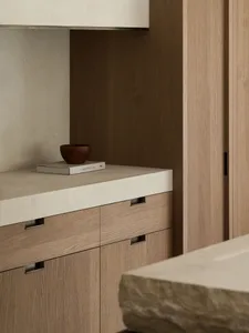 A modern kitchen with wooden cabinets and a stone countertop, creating a warm and inviting atmosphere