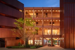 A modern lobby and dining area with a red brick exterior, concrete floors, and natural light from the atrium
