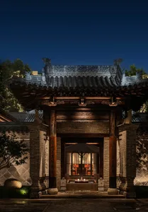 A traditional Asian building with a large wooden structure, featuring a dragon roof and elegant interior with a dining area and wooden furniture