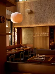 Warm and inviting restaurant with a dining area, bar, and wood and brick elements, featuring soft and warm lighting