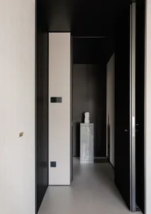 A dark and narrow hallway with wooden walls, a tile floor, and a statue on display, creating a simple and elegant atmosphere