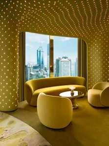 A modern living room with a couch, chair, and dining table, featuring a large window with a city view, yellow and white colors, and bright lighting