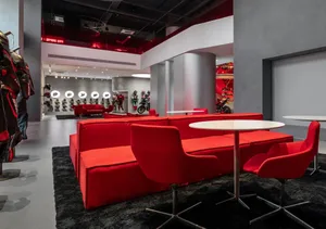A modern living room with a red carpet, a white table, a large couch, and a chair, with soft and warm lighting creating a cozy atmosphere