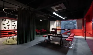 溫馨餐廳內部，配有大型餐桌、木椅和一台縫紉機，燈光柔和營造溫暖氛圍