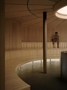 A man sits on a wooden bench in a calm and relaxed room with a pillar and wooden structure