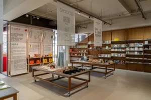 A well-lit bookstore with books on wooden shelves, a cozy atmosphere, and natural light from windows