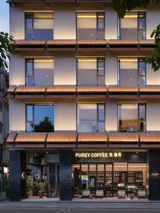 A welcoming coffee shop with a modern wooden building, large window, and natural lighting