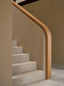 A modern staircase in a residential setting with a wooden staircase and brown color, surrounded by a calm and inviting atmosphere