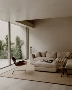 A well-lit living room with a couch, chair, and rug, featuring various decorative items and a cozy atmosphere