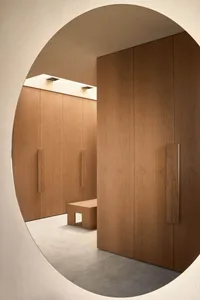 A bright and welcoming hallway with a wooden door and bench, illuminated by natural light