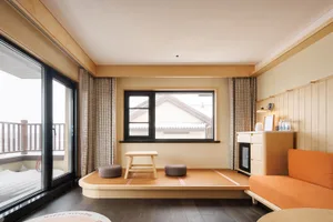 溫馨現代臥室，配有床鋪、桌子和椅子，特色為木質地板、牆面和家具，從窗戶灑入自然光線