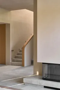 A wooden staircase in a residential hallway with natural light and a warm atmosphere