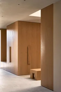 Well-lit hallway with wooden walls and doors, creating a warm and inviting atmosphere
