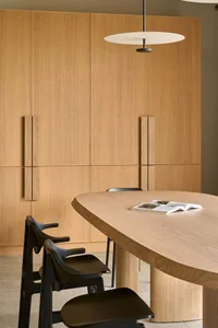 Wooden dining room with a table and chairs, surrounded by books and a cozy atmosphere