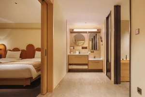 Modern bathroom with a wooden door, tile floor and walls, and a bright atmosphere