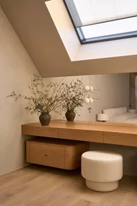 Cozy bedroom with a wooden desk, a bed, and natural light, decorated with a modern and minimalist style