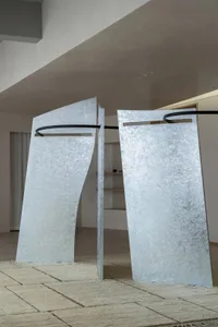 Modern room with two large metal sculptures, white walls, and natural light