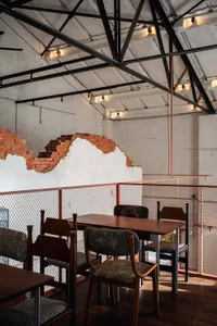 Cozy modern restaurant interior with a wooden table, brick wall, and dim lighting, encouraging social interaction and dining
